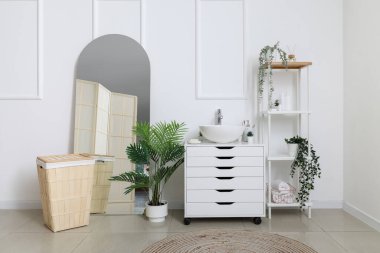 Banyo, çekmeceli, raflı, aynalı ve çamaşır sepetli.