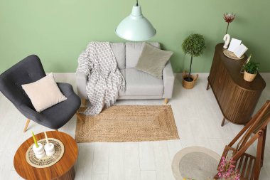 Modern oturma odasının içi gri kanepe, koltuk ve kahve masasıyla dolu.