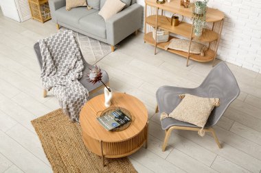 Modern oturma odası. Kahve masası, koltuklar ve raf ünitesi var.