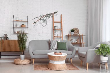 Oturma odasında rahat bir koltuk, kanepe ve masa.