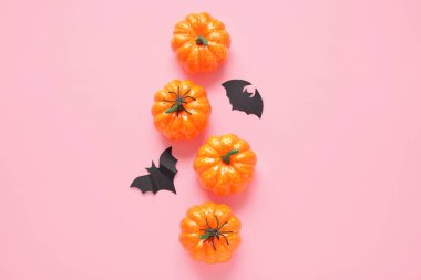 Kabaklarla, yarasalarla ve pembe arka planda örümceklerle kompozisyon. Cadılar Bayramı konsepti