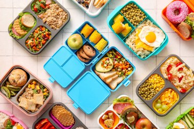 Beyaz fayanslı farklı lezzetli yiyecekleri olan bir sürü beslenme çantası.