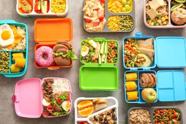 Grunge Grey arka planında farklı lezzetli yemekleri olan bir sürü beslenme çantası.