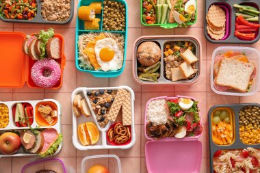 Pembe fayanslı farklı lezzetli yemekleri olan bir sürü beslenme çantası.