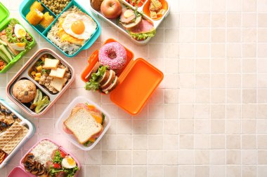 Bej kaplama arka planda farklı lezzetli yemekleri olan bir sürü beslenme çantası.