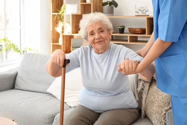 Female Caregiver Helping Senior Woman Stand Home — Stock Photo, Image