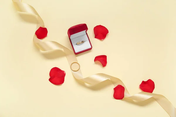 Összetétel Jegygyűrűvel Szalaggal Rózsaszirmokkal Színes Háttéren — Stock Fotó