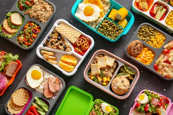 Many Lunchboxes Different Delicious Food Grunge Black Background — Stock Photo, Image