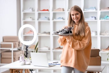 Ayakkabı dükkanında spor ayakkabısı olan kadın satıcı.