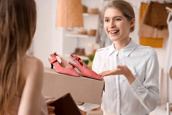 Kvinnlig Säljare Visar Snygga Skor Till Kund Butik — Stockfoto