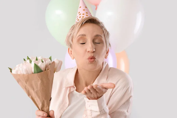 Dojrzałe Kobieta Urodziny Kapelusz Tulipany Wieje Pocałunek Lekkim Tle Zbliżenie — Zdjęcie stockowe