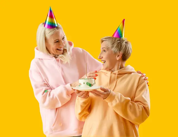Dojrzałe Kobiety Tortem Urodzinowym Żółtym Tle — Zdjęcie stockowe