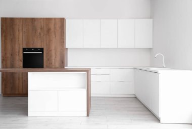 Beyaz tezgahlı ve dahili fırınlı aydınlık mutfağın içi.