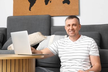 Evde dizüstü bilgisayarla çalışan yetişkin bir serbest çalışan.