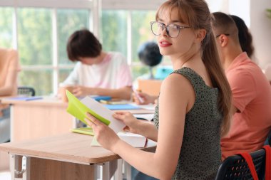 Sınıf arkadaşlarıyla aynı sınıfta ders alan kız öğrenci.