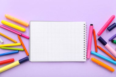 Boş defter ile kompozisyon ve leylak arkaplan üzerinde farklı kırtasiye