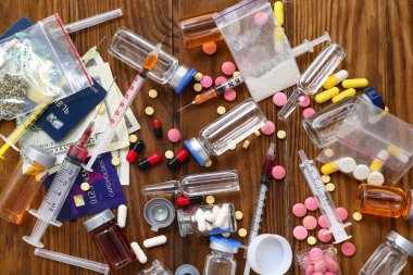 Ahşap arka planda farklı uyuşturucu, şırınga, para ve kredi kartı bileşimi