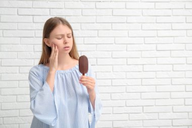 Hassas dişleri ve beyaz tuğlalı dondurması olan genç bir kadın.