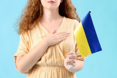 Mavi arka planda Ukrayna bayrağı olan güzel genç bir kadın.