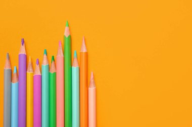 Sarı arkaplanda renkli kalemler grubu