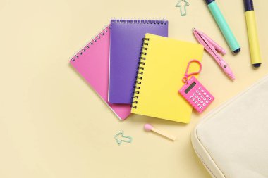 Bej arka planda farklı okul kırtasiyesine sahip kalem kutusu, yakın plan