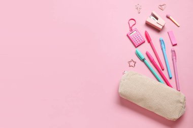 Pembe arka planda farklı okul kırtasiyesine sahip kalem kutusu.