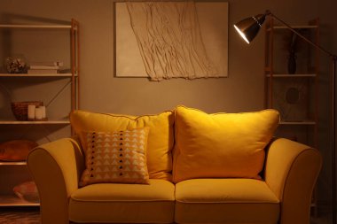 Geceleri kanepede ve parlak lambayla oturma odasının içinde.