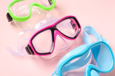 Pembe arka planda farklı yüzme maskeleri, yakın plan