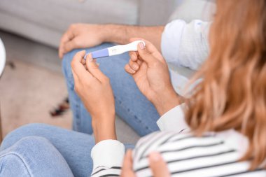 Evinde hamilelik testi olan mutlu genç çift, yakın plan.