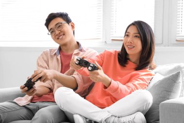 Genç Asyalı arkadaşlar evde video oyunu oynuyorlar