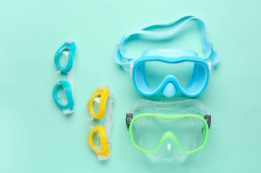 Renk arkaplanında şnorkelli maskeler ve gözlükler