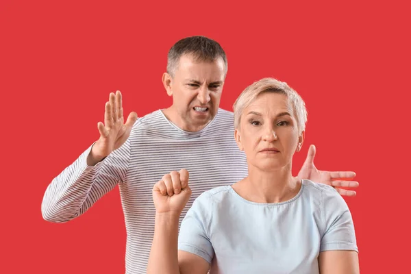Mature Woman Clenched Fist Her Quarreling Husband Red Background — Stock Photo, Image