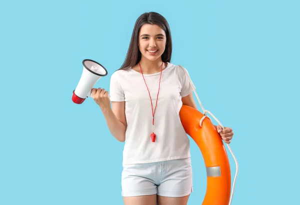 Female lifeguard with ring buoy and megaphone on blue background