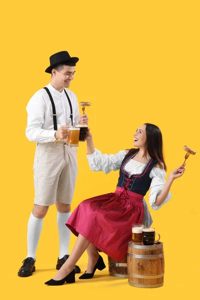 Νεαρό Ζευγάρι Παραδοσιακά Γερμανικά Ρούχα Μπύρα Και Λουκάνικα Κίτρινο Φόντο — Φωτογραφία Αρχείου