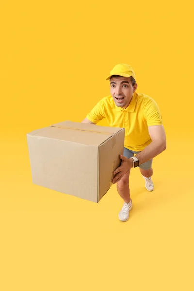 Mannelijke Koerier Met Pakket Uitgevoerd Gele Achtergrond — Stockfoto