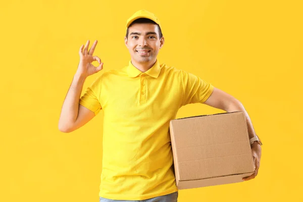 Mannelijke Koerier Met Pakket Tonen Gele Achtergrond — Stockfoto