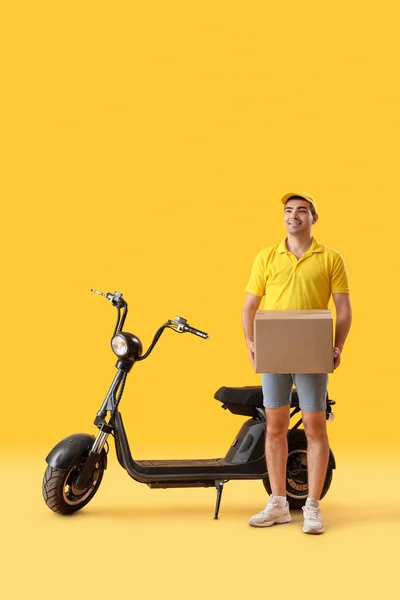 Männlicher Kurier Mit Paket Und Fahrrad Auf Gelbem Hintergrund — Stockfoto