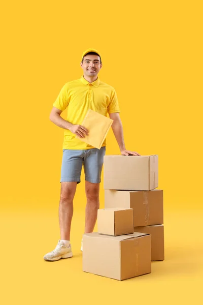 Männlicher Kurier Mit Paketen Auf Gelbem Hintergrund — Stockfoto