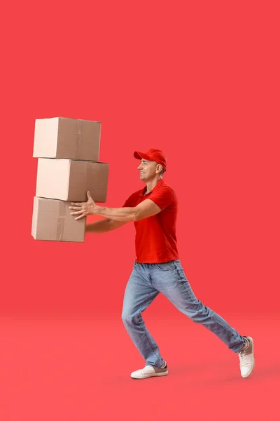 Ältere Kurier Mit Paketen Auf Rotem Hintergrund — Stockfoto