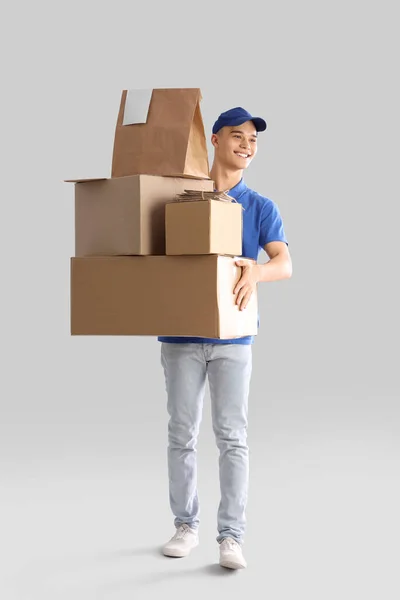 Young Courier Parcels Light Background — Stock Photo, Image