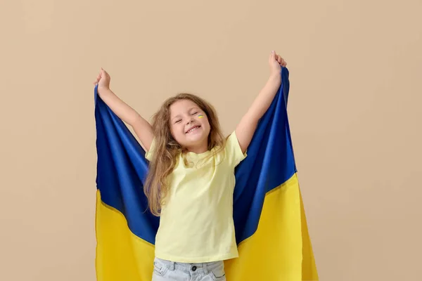 stock image Happy little girl with Ukrainian flag on beige background