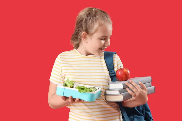 Kırmızı Arka Planda Beslenme Çantası Elma Kitapları Olan Mutlu Küçük — Stok fotoğraf