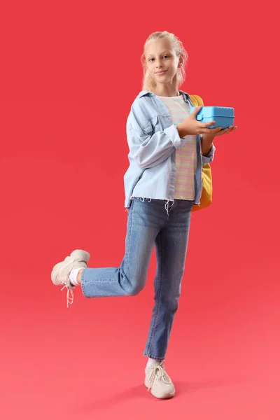 Glückliches Mädchen Mit Rucksack Und Lunchbox Auf Rotem Hintergrund — Stockfoto
