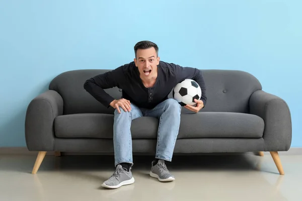 Shocked Young Man Ball Watching Soccer Game Sofa Blue Wall — Stock Photo, Image