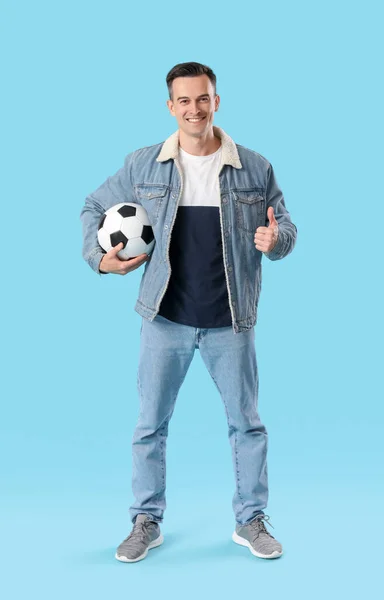 Junger Mann Mit Fußball Zeigt Daumen Nach Oben Auf Blauem — Stockfoto
