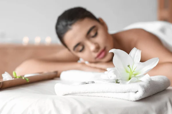 Kwiat Lilii Ręcznikiem Kąpielowym Kamieniami Spa Pobliżu Relaksującej Kobiety Salonie — Zdjęcie stockowe