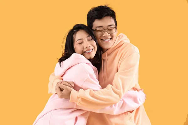 Young Asian Friends Hugging Yellow Background — Stock Photo, Image