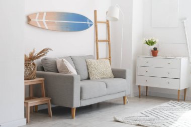 Sörf tahtası, kanepesi ve tuvaleti olan aydınlık yatak odası.