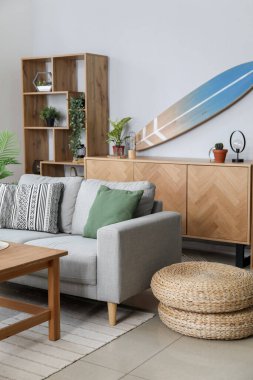 Sörf tahtası ve kanepesi olan bir oturma odası.