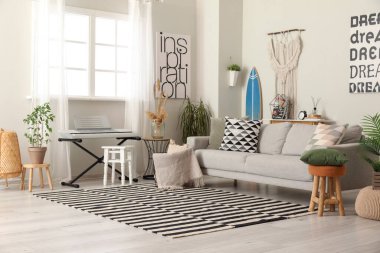 Sörf tahtası, sentezleyici ve kanepesi olan şık bir oturma odası.